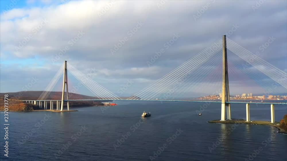 Beautiful hyper lapse of cable-stayed Russian bridge across the Eastern Bosphorus strait, and motor boats floating under it. Vladivostok, Russia. Nice sunny day. Beautiful hyper lapse of cable-stayed Russian bridge across the Eastern Bosphorus strait, and motor boats floating under it. Vladivostok, Russia. Nice sunny day.