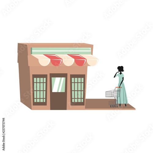 Fototapeta Naklejka Na Ścianę i Meble -  woman silhouette with shopping cart in store facade