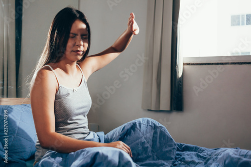 Girl upset waking up with the light bothering her lying on a bed in the morning photo