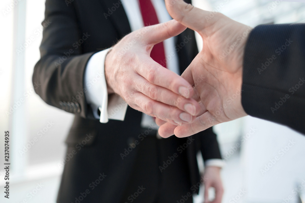 close up.business partners stretching out their hands for a handshake