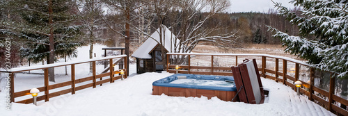 Panorama, outdoor Jacuzzi pool with fresh blue water in winter in Finland. Sauna and Finnish traditions.