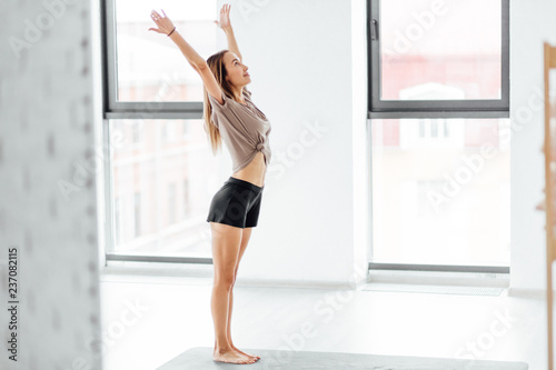 young beautiful girl is happy as she has a holiday. the beggining of a new day. positive mood in the evening . yoga concept. copy space