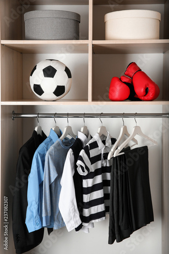 Wardrobe with stylish boy's clothes hanging on rack