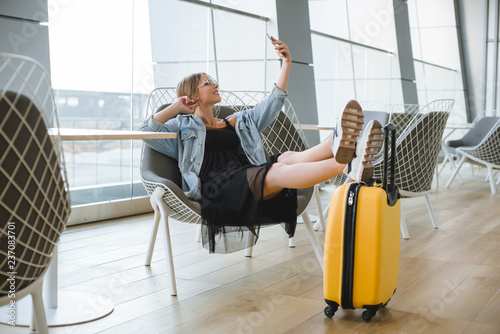 Beautiful young woman at the airport with a blue backpack.