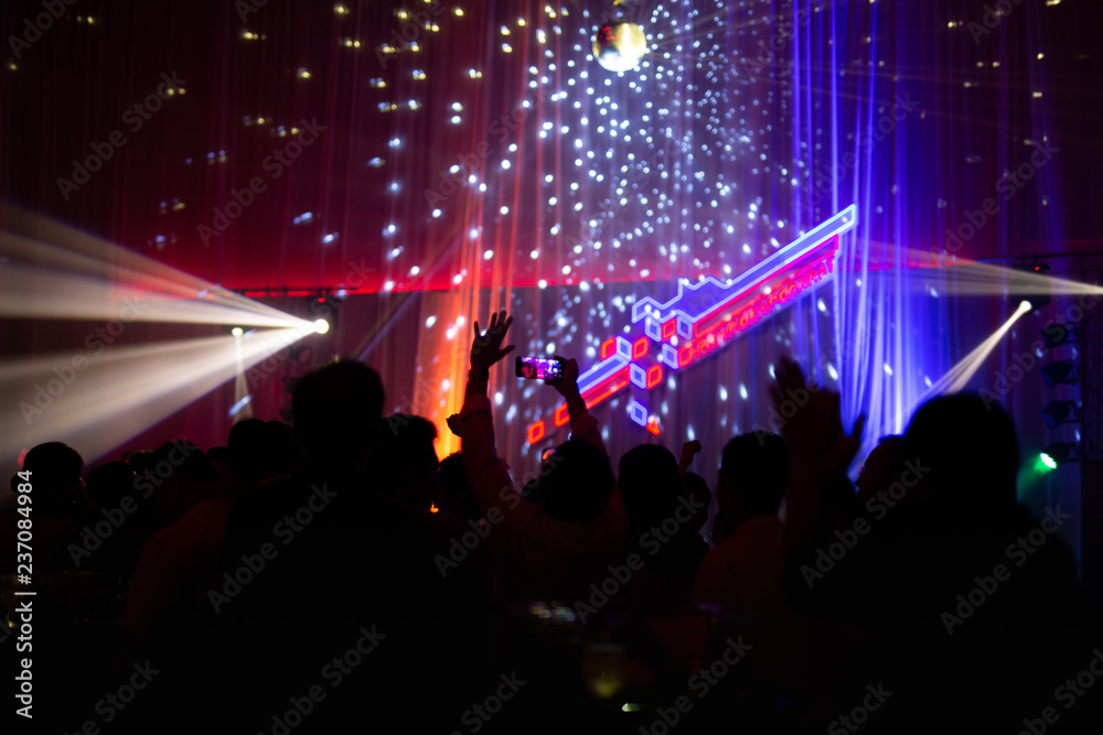 Blurred concept at concert party with audience and colourful led lighting.