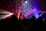Blurred concept at concert party with audience and colourful led lighting.
