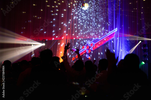Blurred concept at concert party with audience and colourful led lighting.