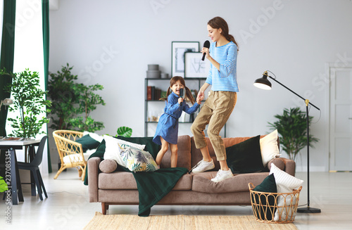 happy family mother and child play at home and sing with combs
