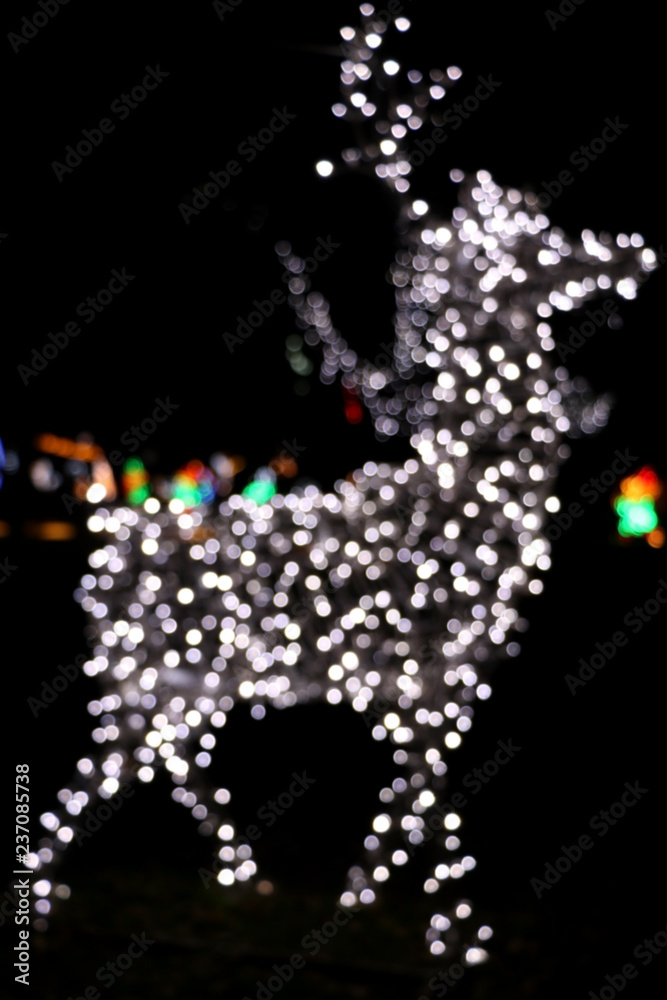 Festive Christmas background with defocused bokeh lights shaped like a deer.