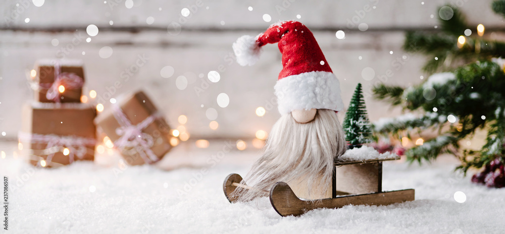 Ho ho ho - Niedlicher Banner mit einem kleinen Weihnachtsmann auf seinem Schlitten in weihnachtlicher Dekoration - obrazy, fototapety, plakaty 