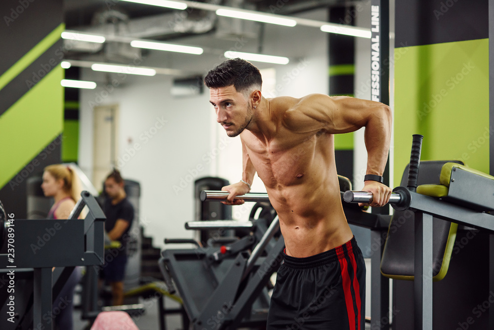 Close up shot of strong healthy man doing push-ups on parallel bars while training in modern gym. Sporty and healthy concept. Dolly shot. Close up shot of strong healthy man doing push-ups on parallel bars while training in modern gym. Sporty and healthy concept. Dolly shot.