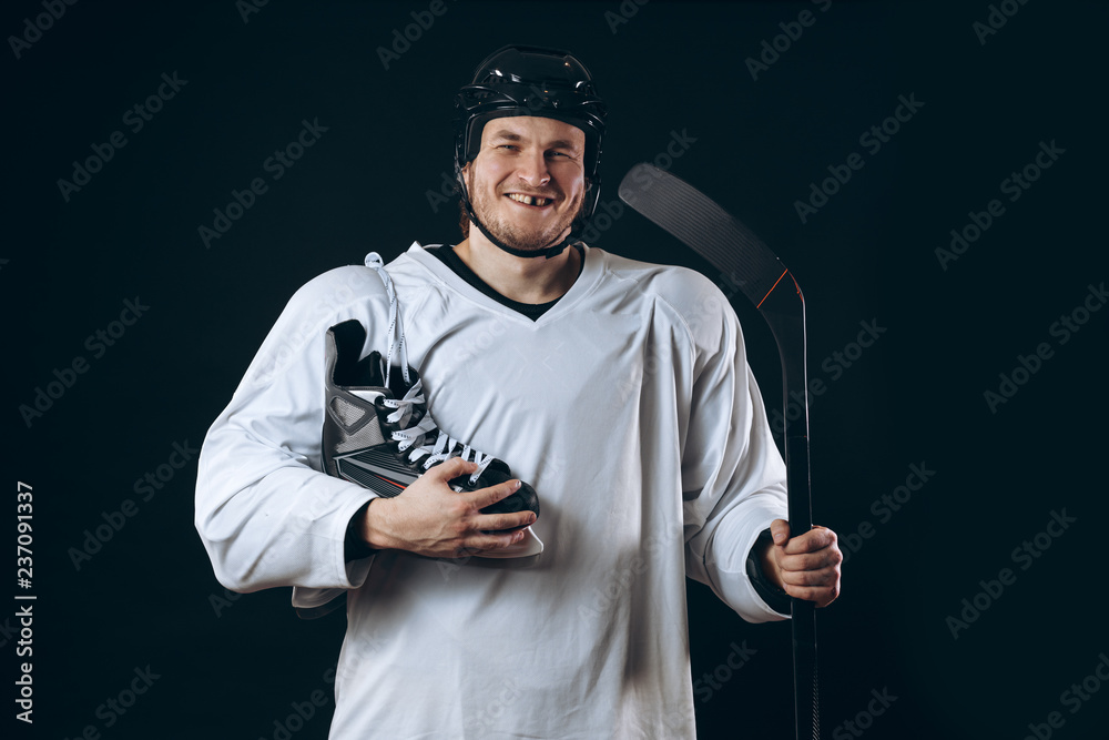 Fototapeta premium Emotional hockey player looking at camera skate and gaming stick . Isolated on black