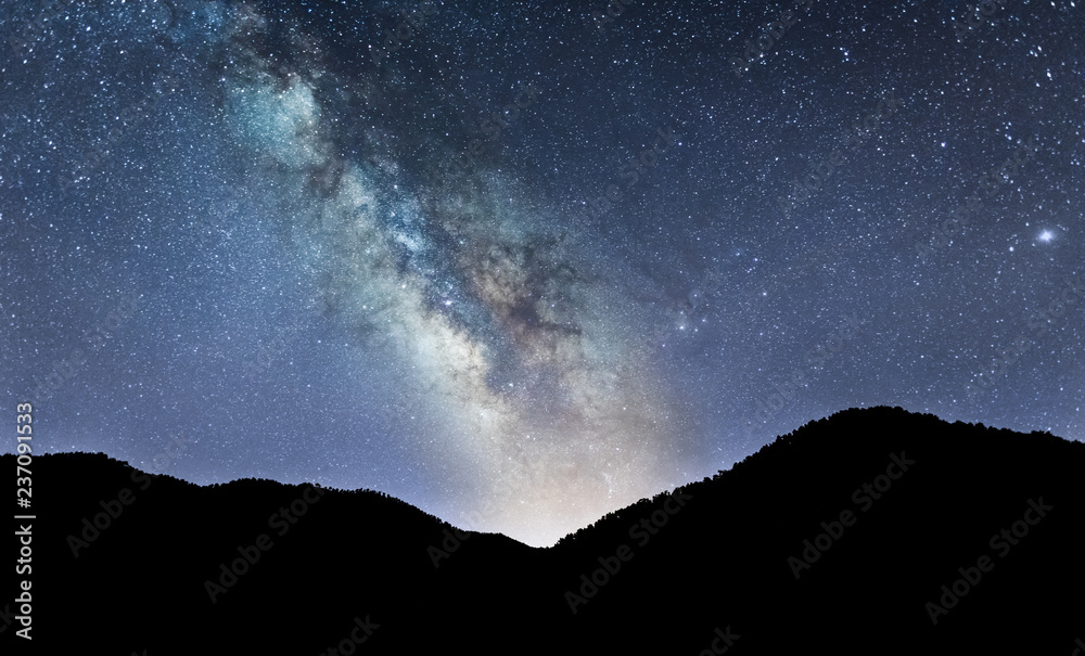 Naklejka Nocny krajobraz z kolorową Drogą Mleczną nad Górami