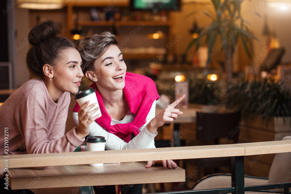 Caucasian female friends in casual wear having lunch at mall cafe laughing,  talking about fashion and shopping. Stock Photo | Adobe Stock
