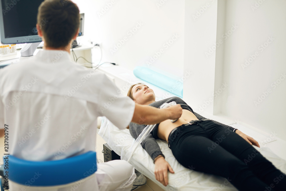 young doctor testing the new ultrasound machine. back view photo. medicine concept. young doctor testing the new ultrasound machine. back view photo. medicine concept.