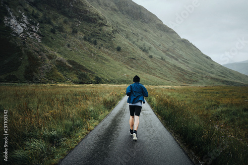 Fototapeta Naklejka Na Ścianę i Meble -  Man jogging through the Highlands