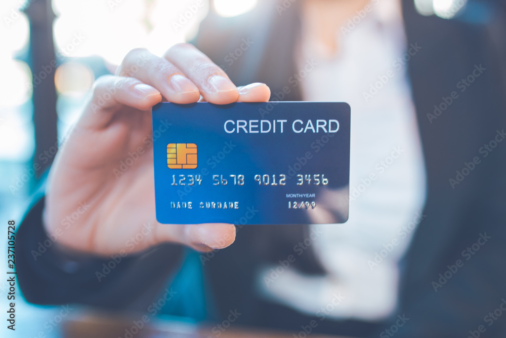 Business woman hand holds a blue credit card.