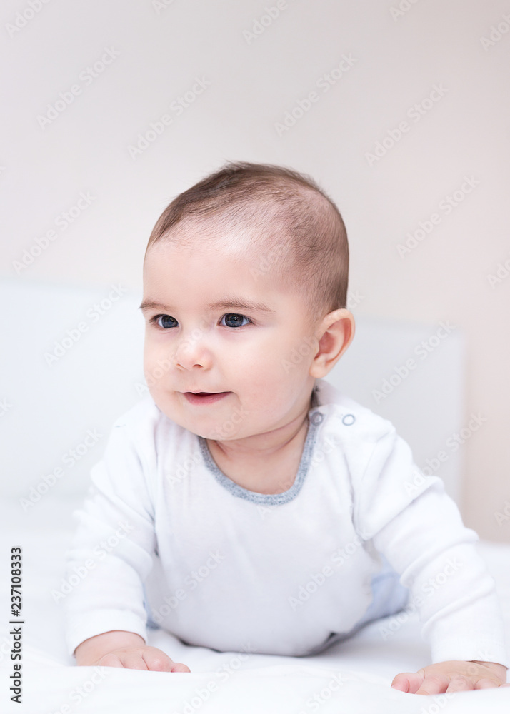 Little cute baby is crawling on a white bed Little cute baby is crawling on a white bed