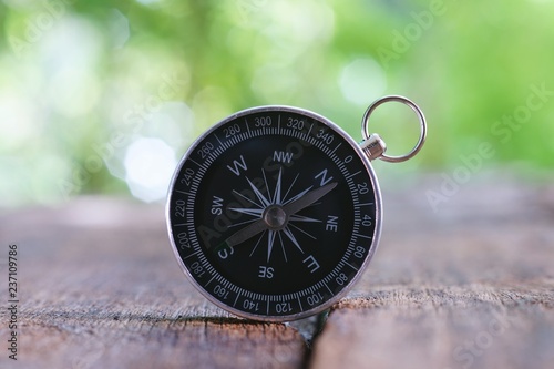 Vintage compass on old wooden table background with smooth blur background, copy space