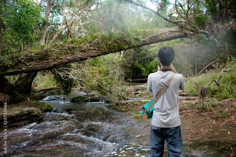 traveler take a photo of waterfall at Phu Kra Dueng National Park, Loei Thailand traveler take a photo of waterfall at Phu Kra Dueng National Park, Loei Thailand