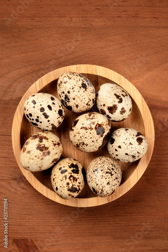 Quail eggs, shot from above on a dark rustic wooden background with copy space