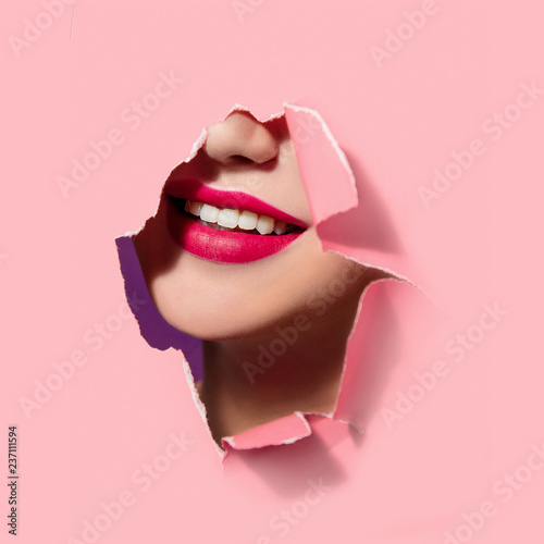 Beautiful red lips in pink paper frame. Plump lips, woman face. Smile, white teeth