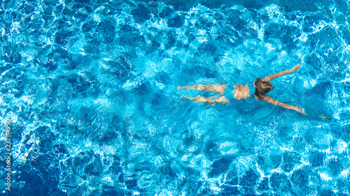 Active girl in swimming pool aerial drone view from above  young woman swims in blue water  tropical vacation  holiday on resort concept  
