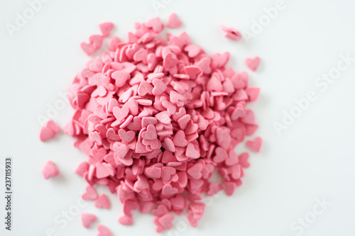 Fototapeta Naklejka Na Ścianę i Meble -  Many pink hearts candy sprinkles on white background