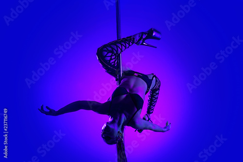 Slim sexy woman in a black lingerie dancing on a pylon