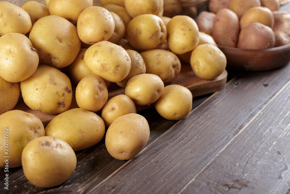 Fresh potatoes on the wood background