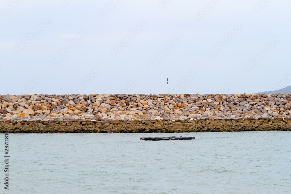 barrier and rock dam, protection seawater and wave at the estuary,stones to protect the shore from the surf of the sea waves barrier and rock dam, protection seawater and wave at the estuary,stones to protect the shore from the surf of the sea waves