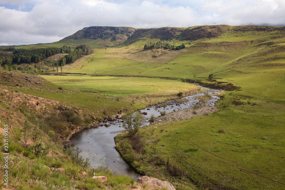 Rural river winds through green hills and countryside