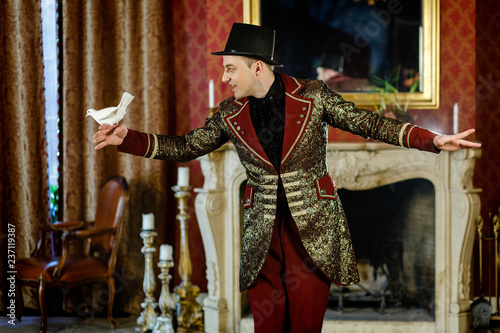 an illusionist is holding a dove in his hands. The magician shows a performance