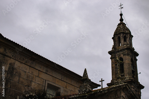 Ancient stone church with tower and crosses. Medieval monastery details. Exterior of catholic catherdal. Old temple with cross on cloudy day. Faith and religion concept. 