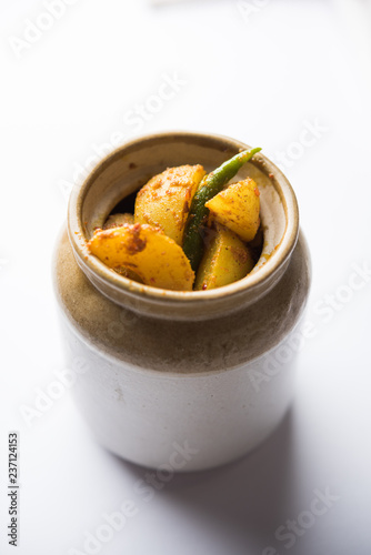 Homemade Gooseberry or amla Pickle/ or Aavle ka Achar in a bowl or barni over moody background.  selective focus photo