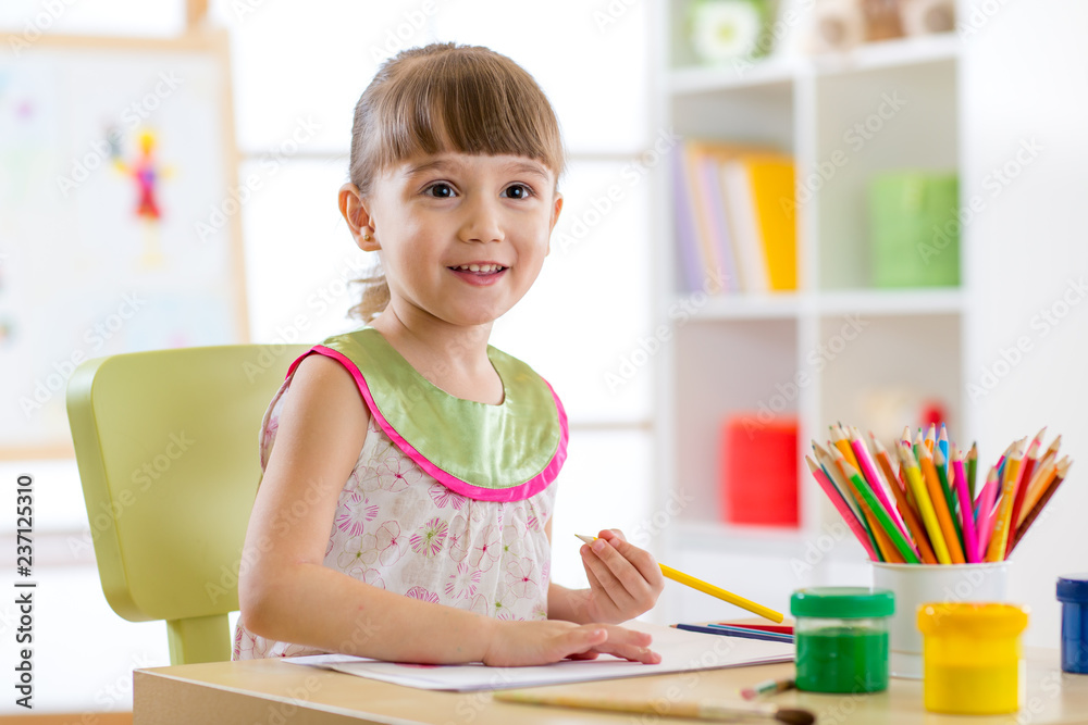 Cute little girl is drawing with pencils in preschool Cute little girl is drawing with pencils in preschool