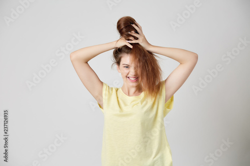 Girl in yellow t-shirt fooling around with her hair