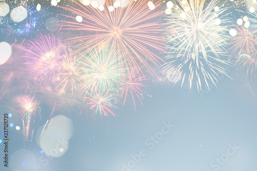 Fireworks colorful explosions on blue, festive background with copy space