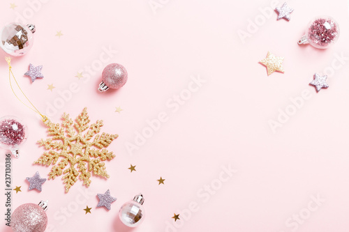 Christmas composition. Xmas pink decor holiday ball with ribbon on pink background.