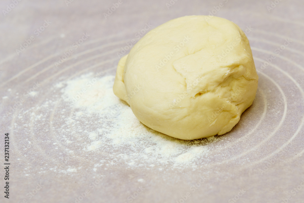 Homemade dough is cut in half on a floured surface. Homemade dough is cut in half on a floured surface.