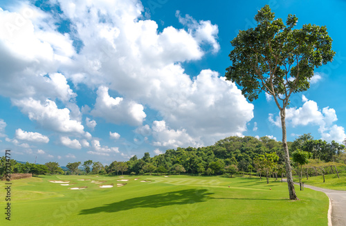 The beautiful view green grass , sand bunker at golf course with blue white cloud sky background