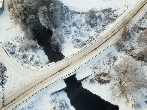 Aerial view of forest and river covered with snow , bird's eye view