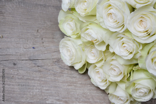 White roses on wooden background © Elena