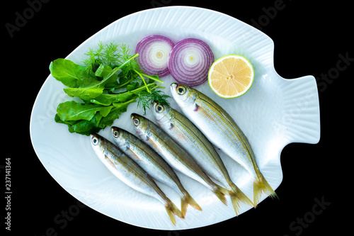 Bogue fish also known as Boops boops with rockets leaves served on white plate