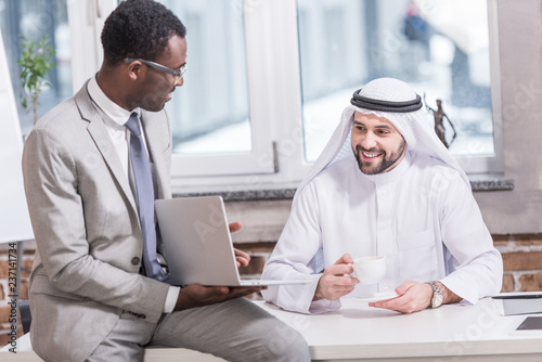 Arabian businessman looking at laptop in office © LIGHTFIELD STUDIOS