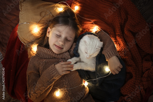 girl child sleeps embrace with cat blanket