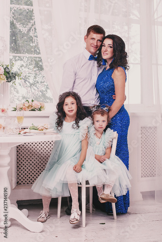 Happy family spending time together and look at camera. Family of mother, father and two daughters photo