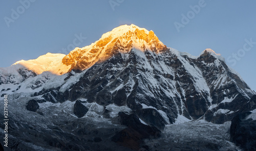 Bild auf Leinwand Close-up view of Annapurna South montain peak against clear blue sky during sunr