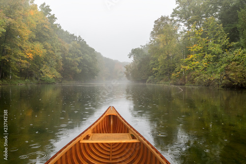 Cedar canoe on a river during a light rain