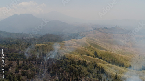 aerial view forest fire smoke on slopes hills. wild fire in tropical forest  Java Indonesia. natural disaster fire in Southeast Asia